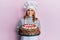 Hispanic young chef woman holding chocolate cake smiling with a happy and cool smile on face