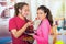 Hispanic young healthy couple enjoying breakfast together, sharing fruits and smiling, home kitchen background