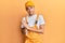 Hispanic young man wearing handyman uniform clapping and applauding happy and joyful, smiling proud hands together