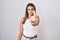 Hispanic young woman standing over white background showing middle finger, impolite and rude fuck off expression