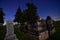 An historic above ground tomb reflects moonlight on a dark night in city cemetery in Wisconsin