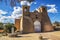 Historic adobe San Francisco de Asis Mission Church in Taos New Mexico in dramatic late afternoon light under intense blue sky