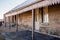 Historic Australian sandstone brick cottage exterior with verandah patio, corrugated iron roof