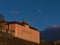 Historic building in the evening light above vineyard slopes with clear blue sky and visible moon in town Meersburg.