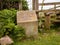 Historic concrete marker stone near the wooden style on a Welsh footpath