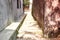 A historic lane with mottled wall extending a mystery yard