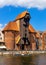 Historic medieval port crane - water gate - surrounded by Hanseatic houses at Motlawa river embankment in old town city center in