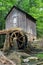 A historic mill in a forest with green leafs in late spring.