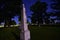 An historic obelisk tombstone reflects moonlight on a dark night in city cemetery in Wisconsin