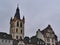 Historic old buildings at square Hauptmarkt in city Trier, Germany with steeple of Catholic church St. Gangolf on cloudy day.