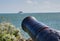 Historic old Large Canon aims out to sea at passenger ferry.