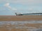 Historic pier at southport merseyside with the beach at low tide and summer sky reflected in water on the beach