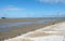 historic pier at southport merseyside with the beach at low tide and summer sky reflected in water on the beach