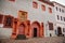 Historic renaissance gray house with red stone gothic arches, wooden doors and coat of arms above entrance, in medieval courtyard