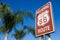 Historic route 66 highway sign with palm tree and a blue sky