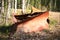 Historic rusty snow plow lying in the forest