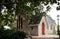 Historic sandstone brick country rural church in shade of large tree