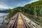 Historic steel truss underspanned suspension railway bridge from 1902 over Bobr River in Pilchowice, Poland at beautiful morning