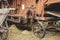 Historic threshing machine in operation. In the foreground is a historic wooden cart for the mown wheat