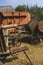 Historic threshing machine with subsequent straw press in operation. In the foreground is a historic wooden cart for the mown