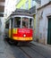 Historic tram no. 28 between the narrow house of the alfama of lisbon, portugal