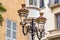 Historic two-armed street lamp in Nice, France, in front of a house facade