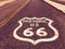 Historic US Route 66 highway sign on asphalt in Oatman, Arizona, United States. The picture was made during a motorcycle road trip