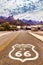 Historic US Route 66 with highway sign on asphalt and a panoramic view of Oatman, Arizona, United States.