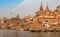 Historic Varanasi city with old architectural buildings and ancient temples along the Ganges river ghat as viewed from a boat.