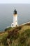 Historic white lighthouse on side of cliff