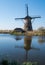 Historic windmill reflected in the water at Kinderdijk, Holland, Netherlands, a UNESCO World Heritage Site.