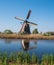 Historic windmill reflected in the water at Kinderdijk, Holland, Netherlands, a UNESCO World Heritage Site.