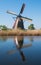 Historic windmill reflected in the water at Kinderdijk, Holland, Netherlands, a UNESCO World Heritage Site.