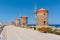 Historic windmills on seaside promenade in Mandrakia port. Rhodes island, Greece