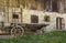 Historic wooden horse driven cart in front of an old farmhouse