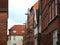 Historical alley with redbrick houses with any guild signs and lanterns at a rainy day