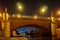 Historical bridge over a river with city lights and christian sculptures at night