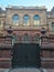 Historical building with ornaments and  fence with wrought iron gates