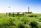 The historical lighthouse Westerhever and a small bridge in the salt meadows, Germany