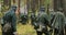 Historical Re-enactment. Re-enactors Dressed German Wehrmacht Infantry Soldiers In World War II Marching Along Forest In