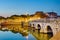 Historical roman Tiberius bridge over Marecchia river during sunset in Rimini, Italy.