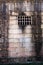 Historical sandstone convict built brick prison building, windows rusting security grill, wall background