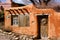 Historical Santa Fe adobe house with old styled wood beams and adobe stucco.
