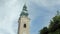 Historical tower with clocks and bronze dome of catholic church against sky in summer