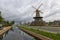 Historical wind mill by a canal in Delft , the Netherlands