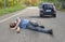 Hit and run concept. Injured man on road in front of a car