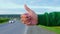 Hitchhiker girl shows thumb way on roadside