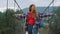 Hitchhiker walking river bridge in mountains nature. Free girl enjoy traveling.