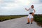 Hitchhiking country girl on rural road