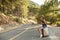 Hitchhiking tourism concept. Travel hitchhiker woman walking on road during holiday travel